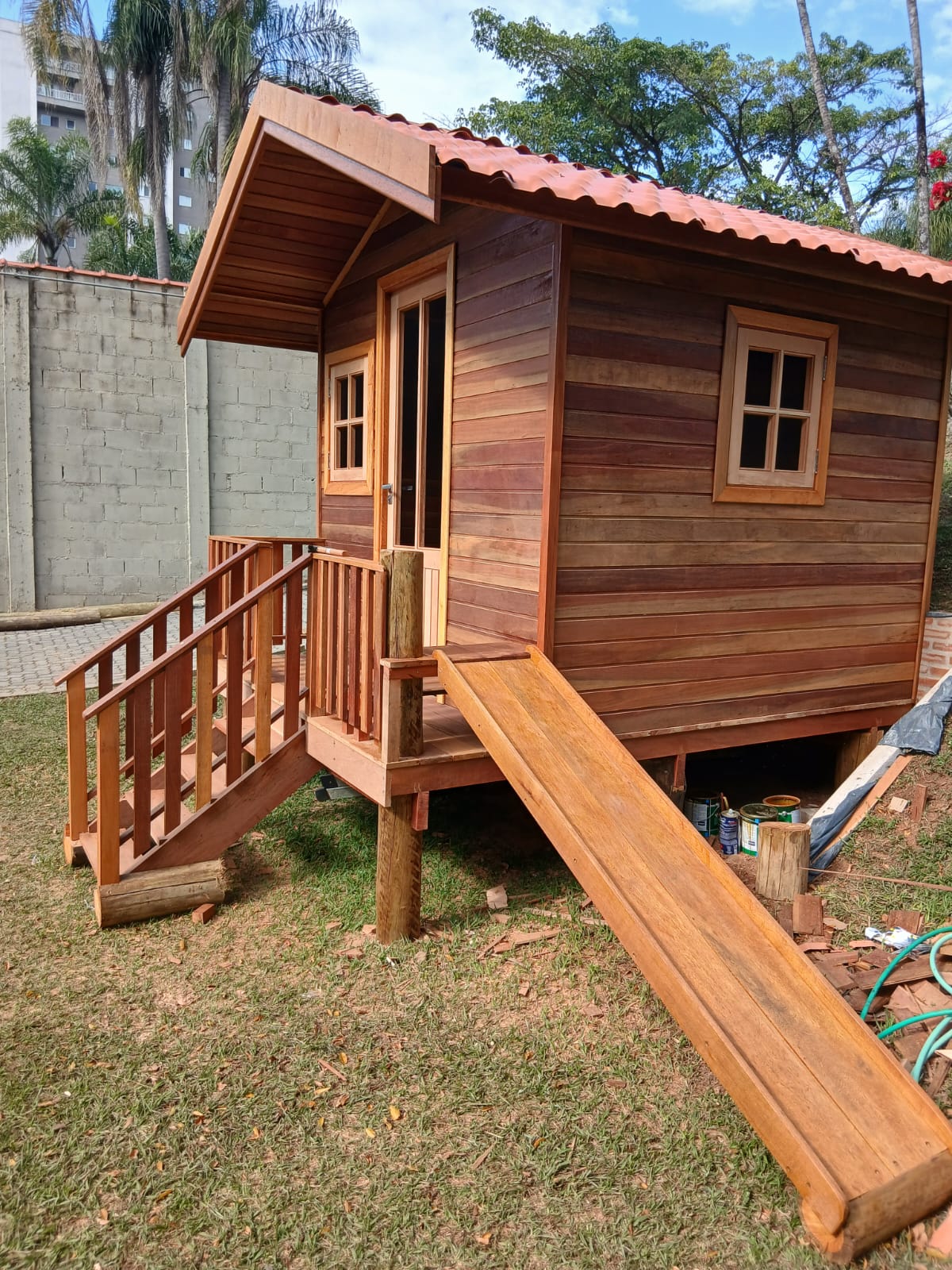 Casinha de madeira com telhado, escada e guarda-corpo